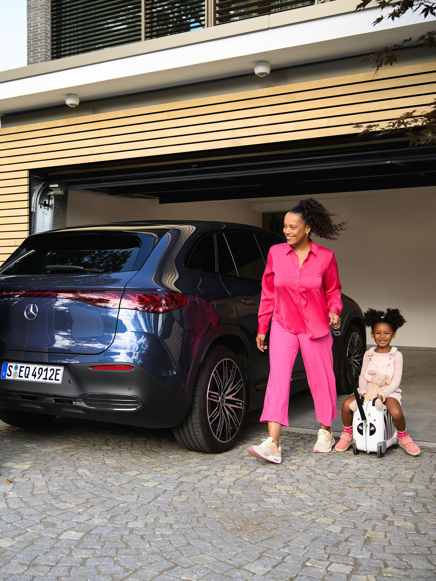 Two people and a child going to their Mercedes-Benz vehicle. Benz vehicle.