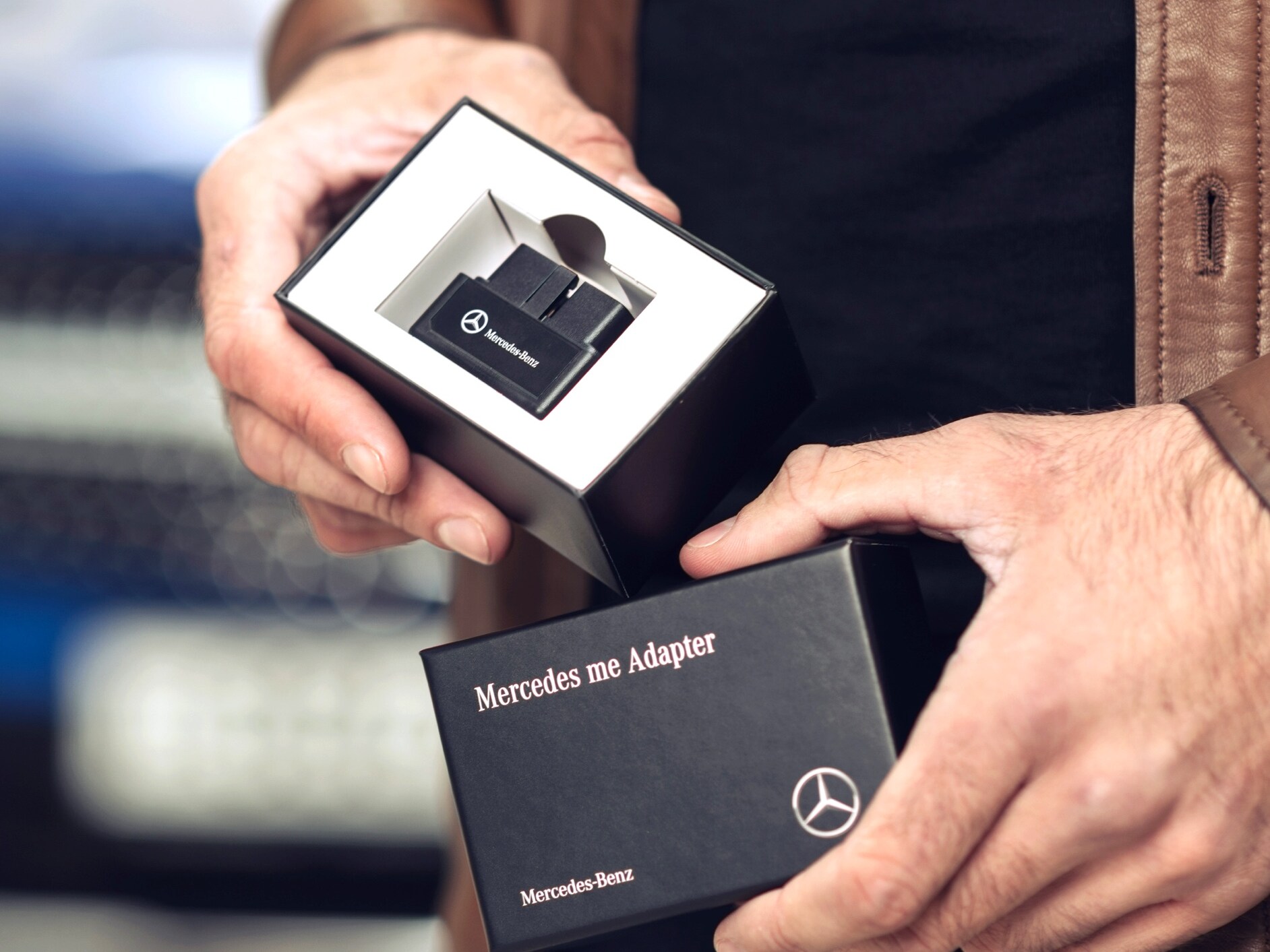 A man unpacks the Mercedes me Adapter for his Mercedes-Benz to be able to use Digital Extras in his vehicle.