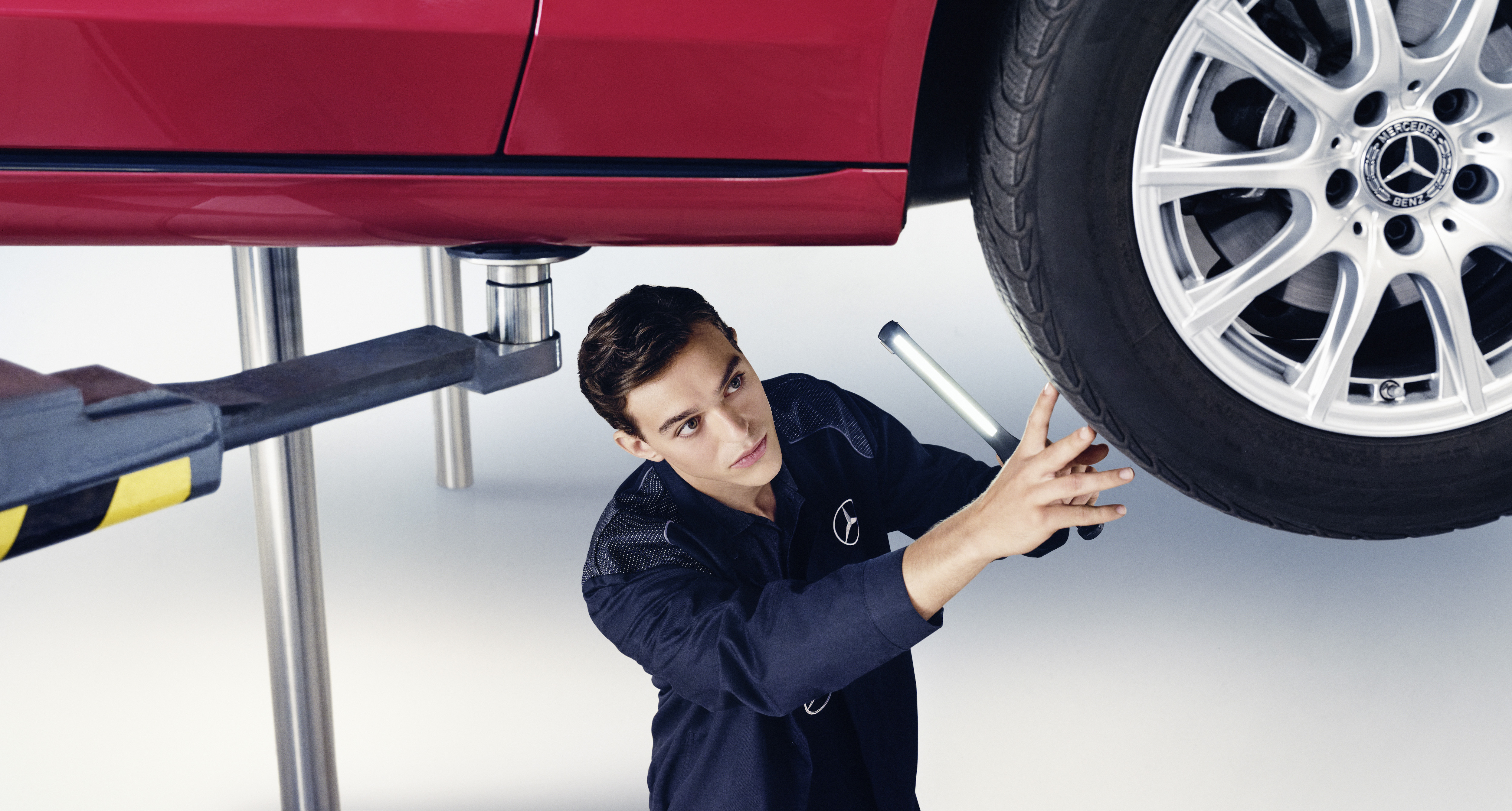 Mercedes-Benz replacement parts A Mercedes-Benz technician checks the underside of a vehicle.