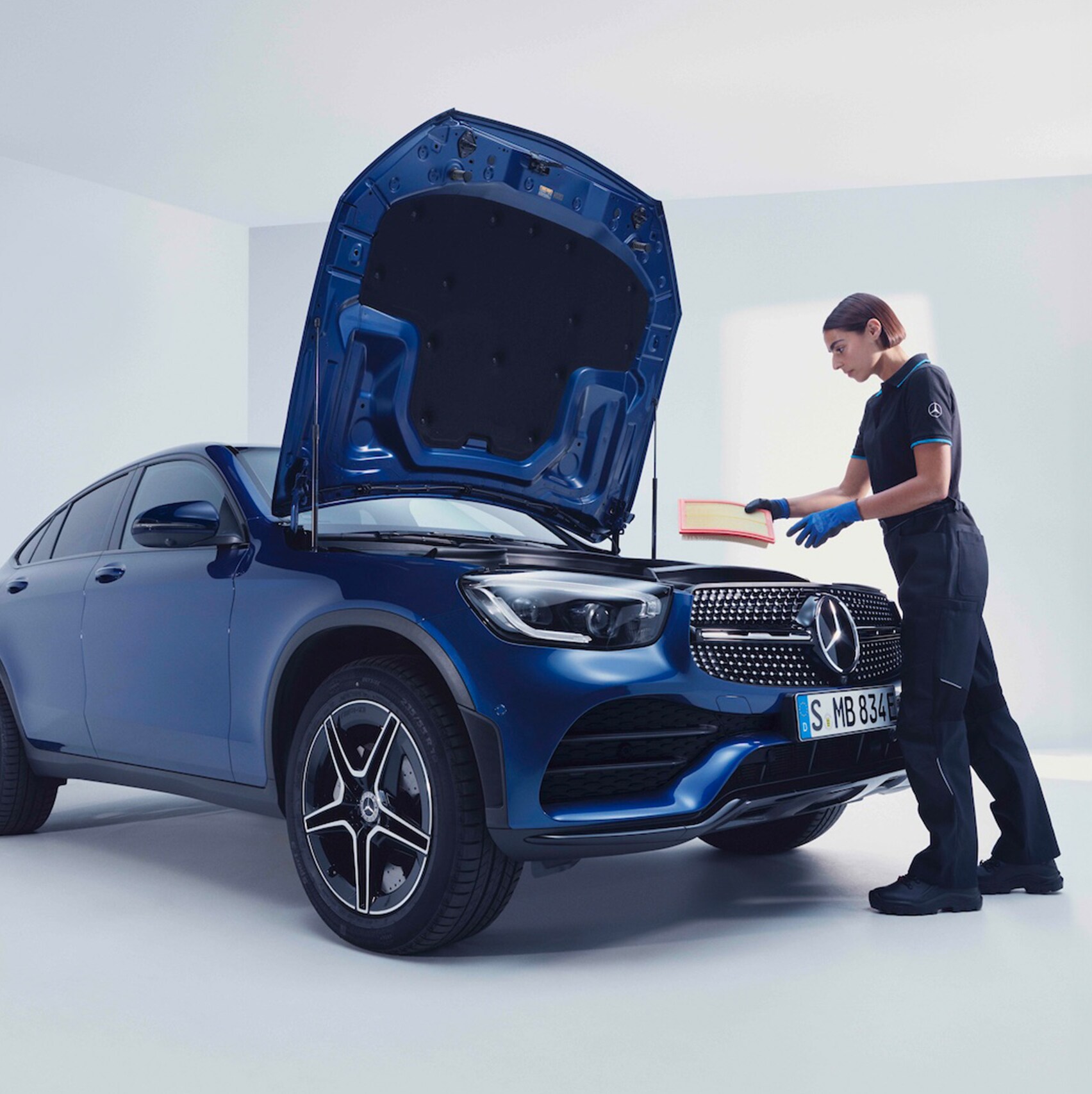 A Mercedes-Benz mechanic examines the wheel of a Mercedes-Benz.