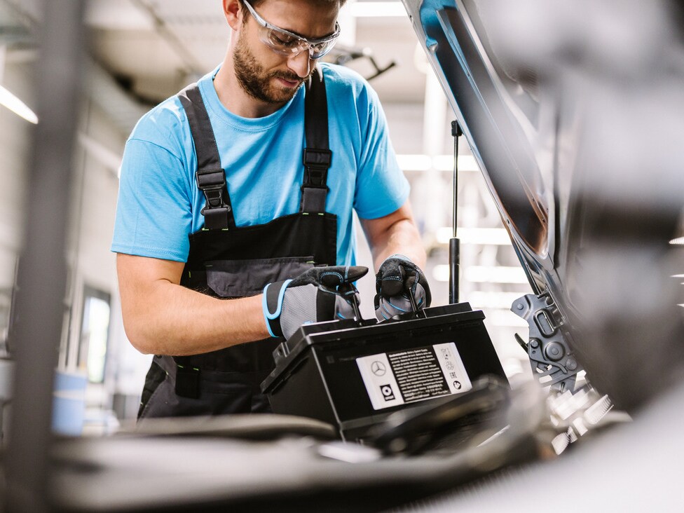 A Mercedes-Benz technician checks the vehicle's electrical system battery.